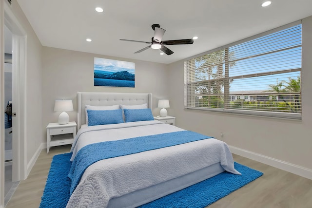 bedroom featuring baseboards, light wood-type flooring, and recessed lighting