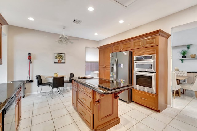 kitchen featuring visible vents, appliances with stainless steel finishes, recessed lighting, dark stone counters, and a kitchen island