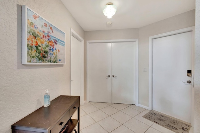 entrance foyer featuring light tile patterned floors and baseboards