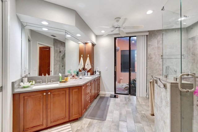 bathroom featuring a shower stall, a sink, a ceiling fan, and wood finished floors