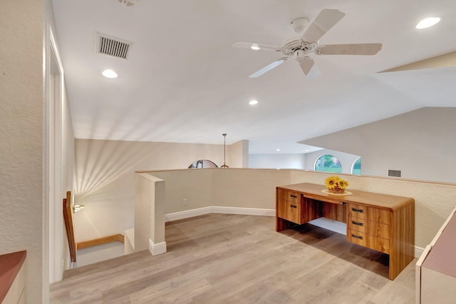 unfurnished office with visible vents, light wood-type flooring, vaulted ceiling, and a ceiling fan