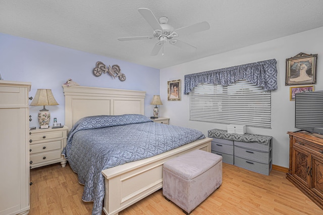 bedroom featuring a ceiling fan, light wood-style floors, and a textured ceiling