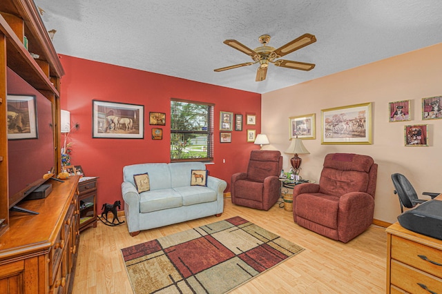 living area featuring a textured ceiling, wood finished floors, and ceiling fan