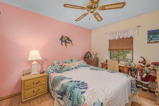 bedroom featuring a ceiling fan, baseboards, and wood finished floors