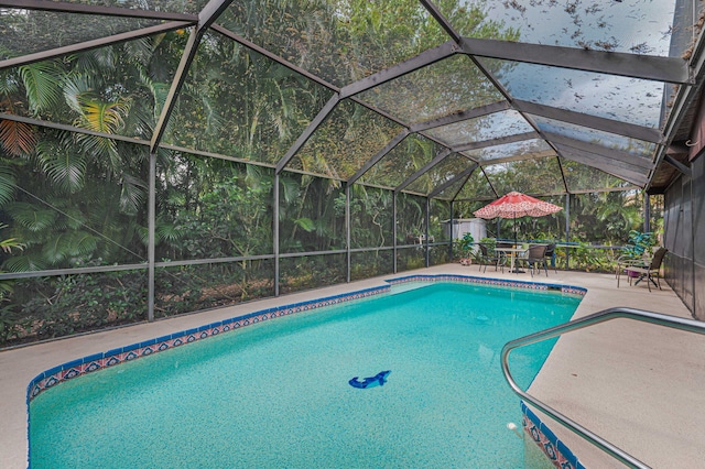 outdoor pool with glass enclosure and a patio