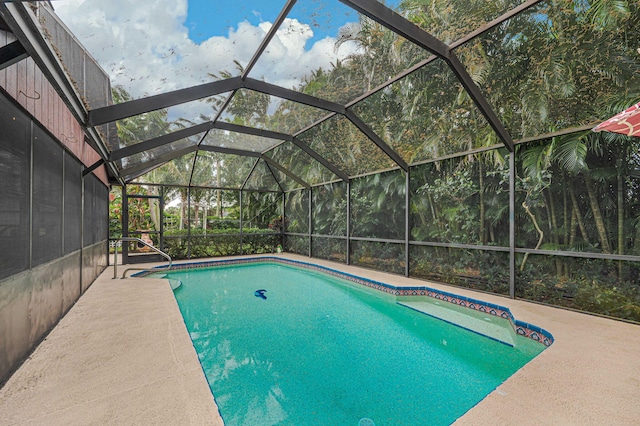 pool featuring glass enclosure and a patio