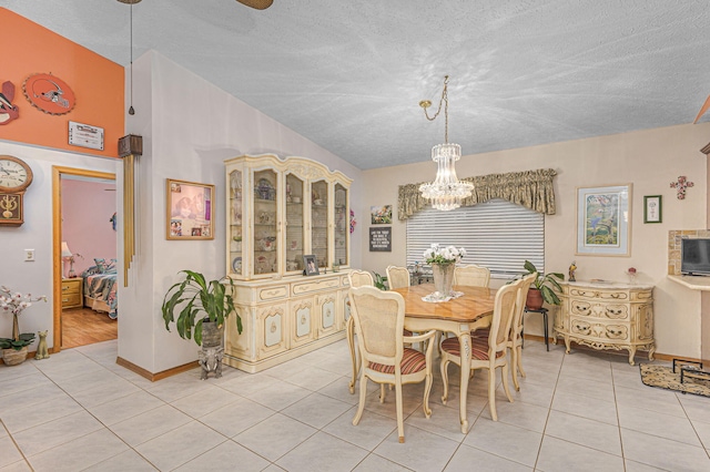 dining room with an inviting chandelier, light tile patterned floors, and a textured ceiling