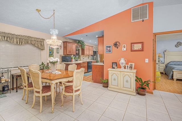 dining room featuring light tile patterned floors, visible vents, lofted ceiling, a textured ceiling, and a notable chandelier