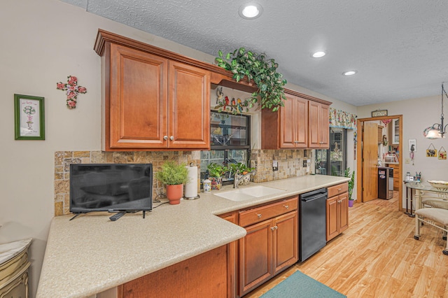 kitchen with a sink, tasteful backsplash, light wood finished floors, dishwasher, and light countertops