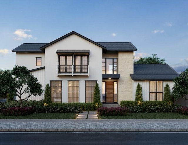 view of front facade featuring a balcony and stucco siding