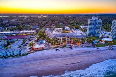 aerial view featuring a water view, a beach view, and a city view