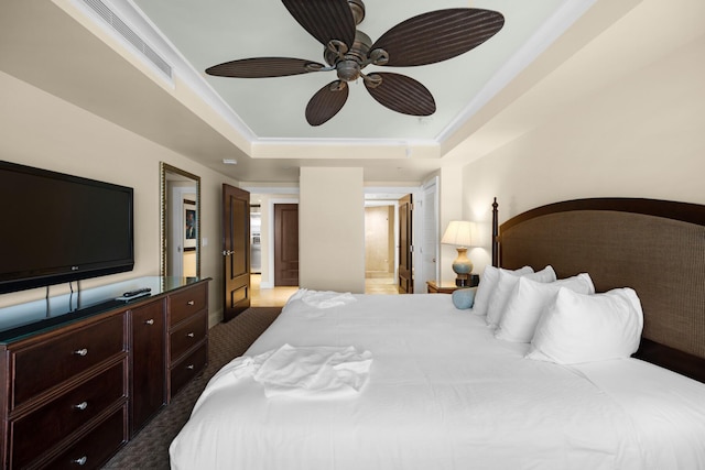 bedroom featuring carpet floors, ceiling fan, a tray ceiling, and ensuite bathroom