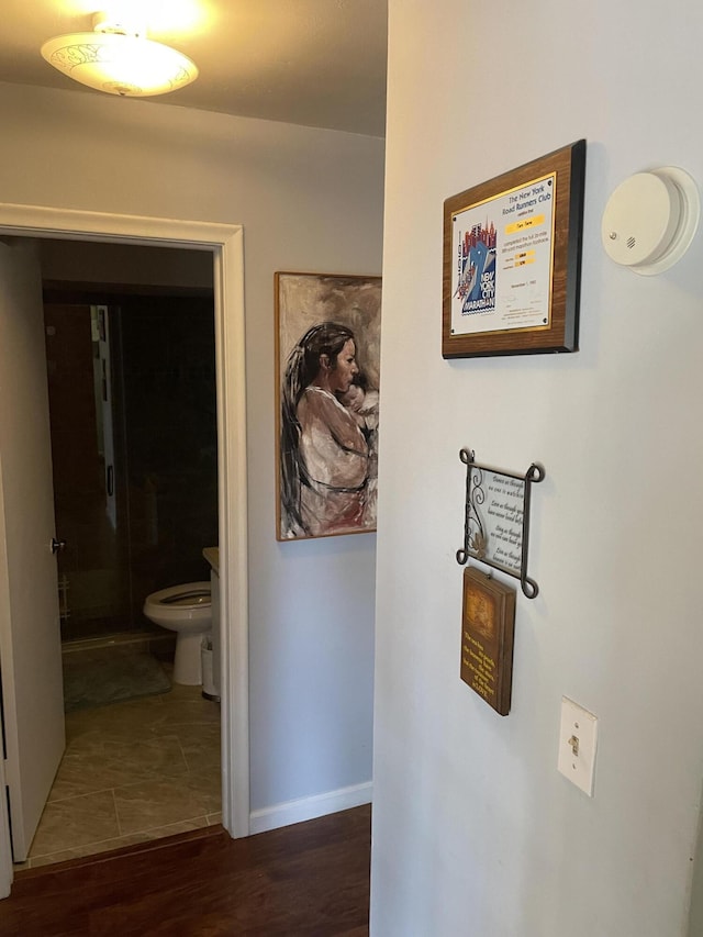 hall featuring baseboards and wood finished floors