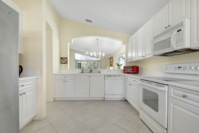 kitchen with a chandelier, white appliances, light countertops, and white cabinetry