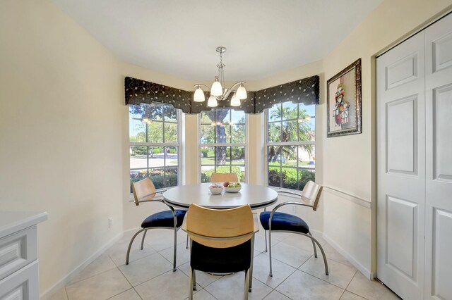 dining area featuring an inviting chandelier, baseboards, and light tile patterned flooring