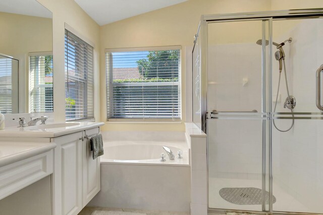 bathroom featuring vaulted ceiling, a stall shower, vanity, and a bath