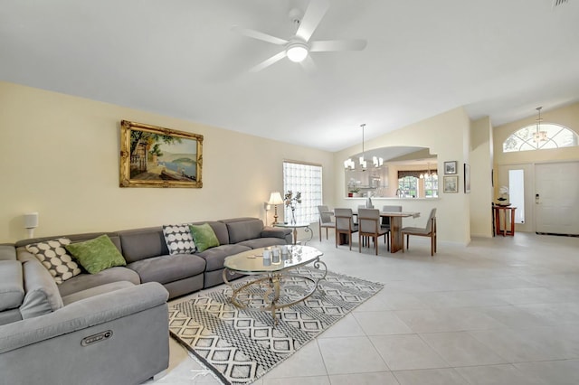 living room with lofted ceiling, light tile patterned floors, and ceiling fan with notable chandelier