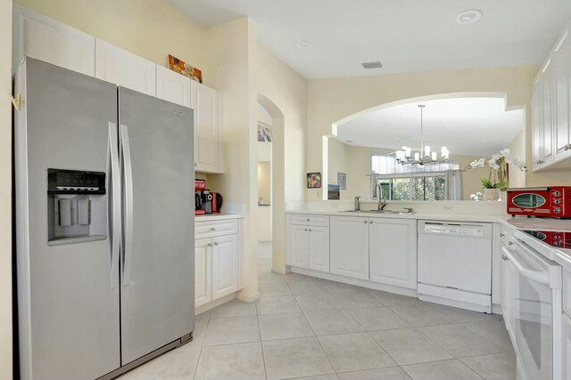 kitchen featuring white appliances, a sink, visible vents, white cabinetry, and light countertops