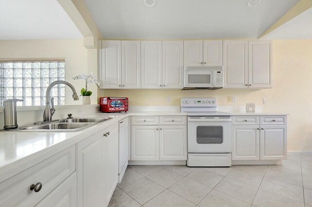 kitchen with light countertops, white cabinetry, a sink, light tile patterned flooring, and white appliances