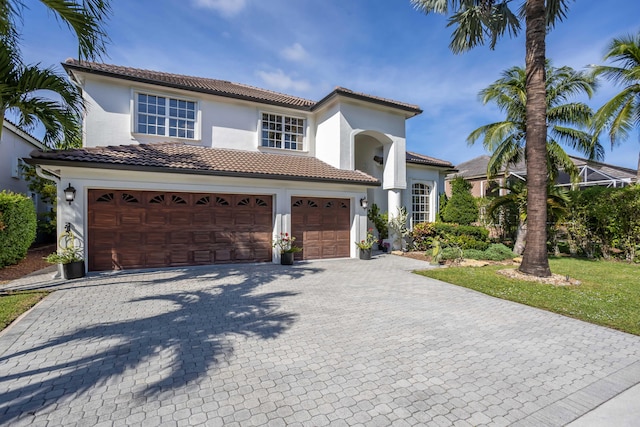 21741 Westmont Ct, Boca Raton, FL 33428 - mediterranean / spanish house featuring an attached garage, decorative driveway, a tiled roof, and stucco siding