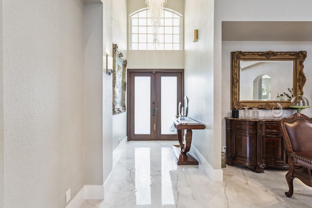 21741 Westmont Ct, Boca Raton, FL 33428 - entryway featuring marble tiled flooring, a textured wall, a towering ceiling, and a chandelier