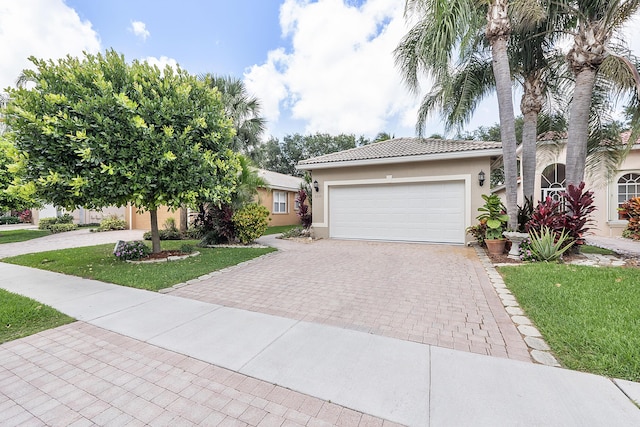 view of front of house with an attached garage, a tile roof, decorative driveway, and stucco siding