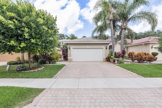 view of front of house featuring a garage, decorative driveway, a tile roof, and stucco siding