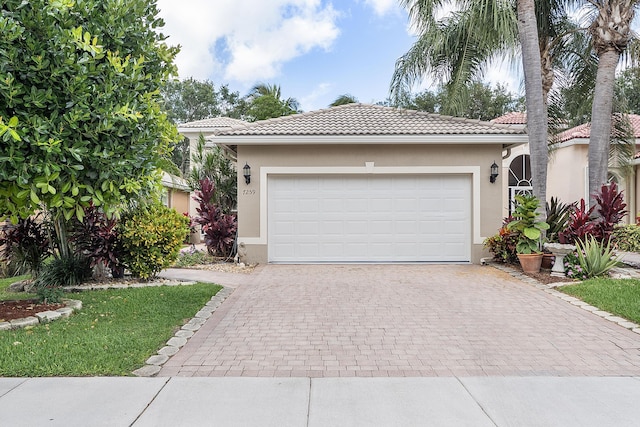 view of front of home featuring decorative driveway, a tile roof, and stucco siding