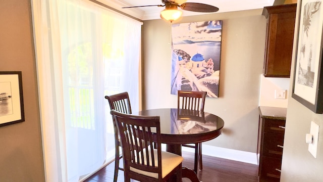 dining space featuring crown molding, baseboards, ceiling fan, and dark wood finished floors