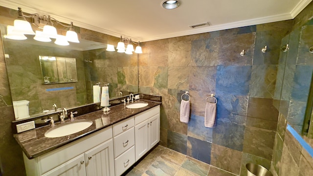 full bathroom with a sink, tile walls, ornamental molding, and visible vents