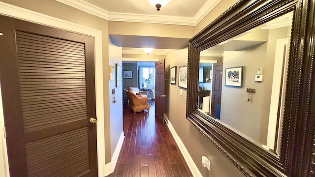 hallway featuring baseboards, ornamental molding, and dark wood-style flooring