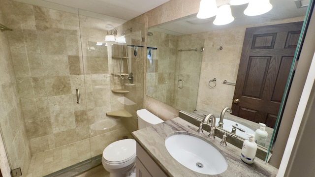 bathroom with vanity, an inviting chandelier, visible vents, toilet, and a shower stall