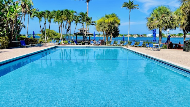 pool with a water view, a gazebo, and a patio area
