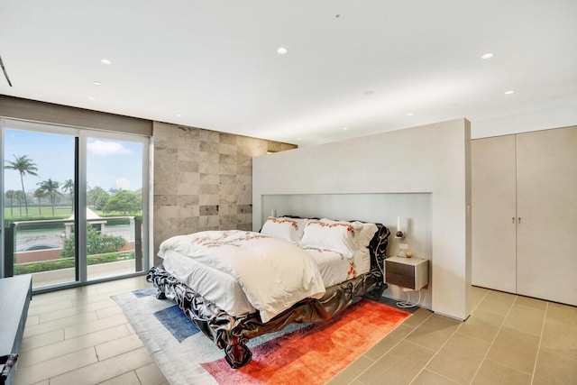 bedroom with access to exterior, recessed lighting, tile walls, and light tile patterned floors