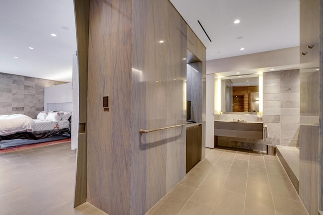 hall featuring tile walls and recessed lighting