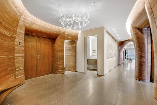 interior space featuring arched walkways, wood walls, and recessed lighting