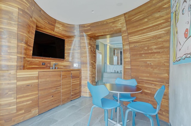 interior space featuring tile patterned flooring and wooden walls