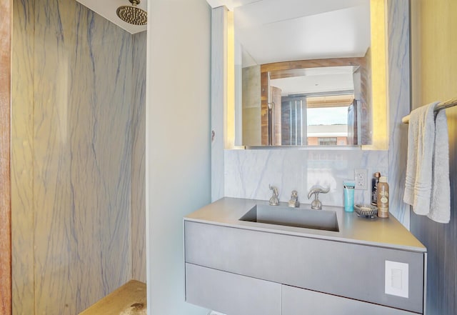 full bathroom with a marble finish shower, decorative backsplash, and vanity