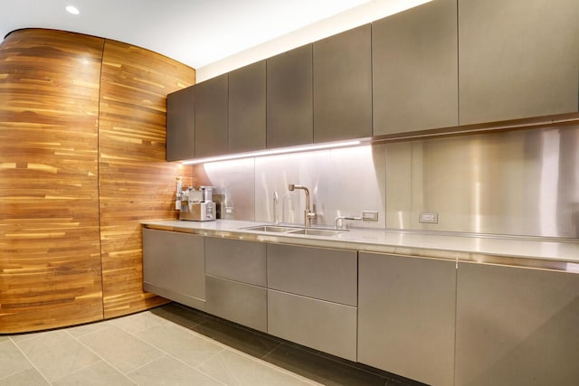 kitchen with light countertops, tile patterned flooring, a sink, and modern cabinets