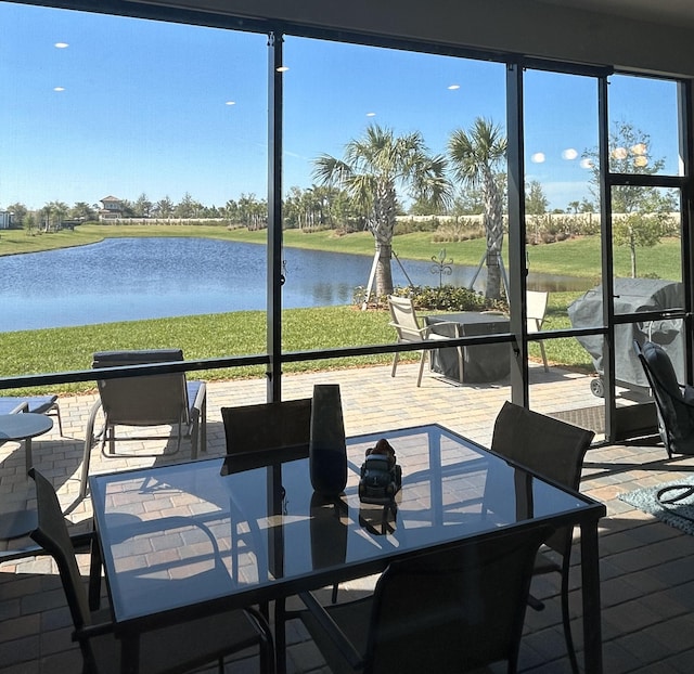 sunroom / solarium featuring a water view and a healthy amount of sunlight