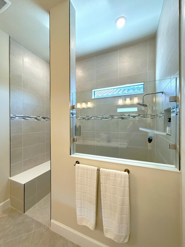 bathroom with tile patterned flooring, visible vents, walk in shower, and baseboards