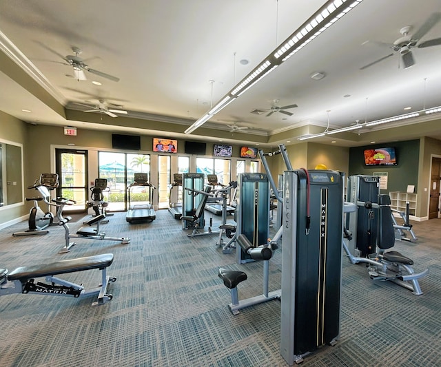 workout area featuring carpet floors, baseboards, a tray ceiling, and ornamental molding