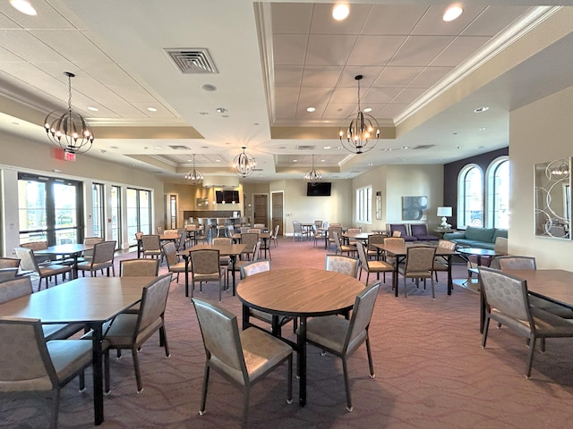 carpeted dining room with a notable chandelier, recessed lighting, visible vents, a raised ceiling, and crown molding