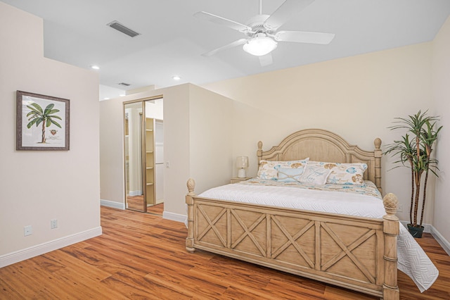 bedroom featuring ceiling fan, light wood finished floors, visible vents, and baseboards