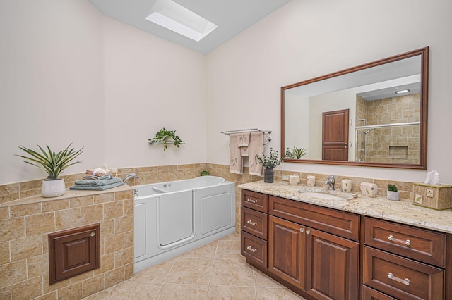 interior space featuring a skylight, laundry area, separate washer and dryer, a sink, and light tile patterned flooring