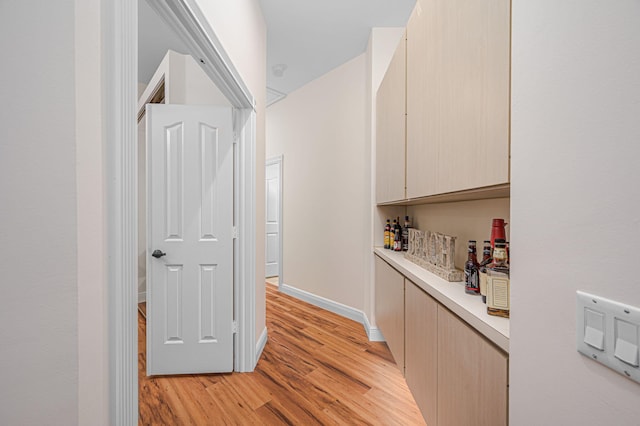 hallway with light wood finished floors and baseboards