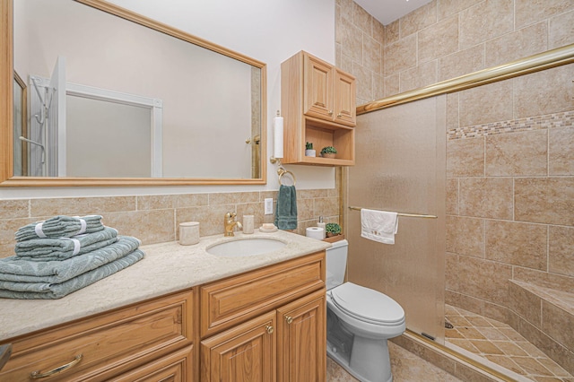 full bathroom with tile walls, tasteful backsplash, toilet, vanity, and tiled shower