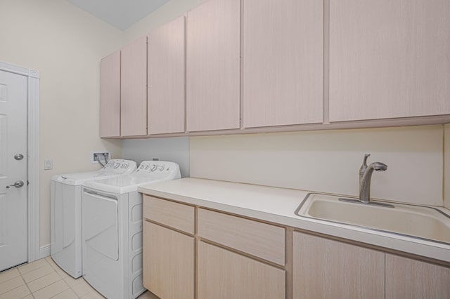 washroom featuring washer and dryer, cabinet space, and a sink