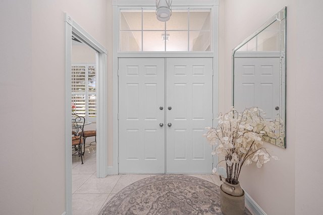 foyer entrance featuring light tile patterned flooring and baseboards