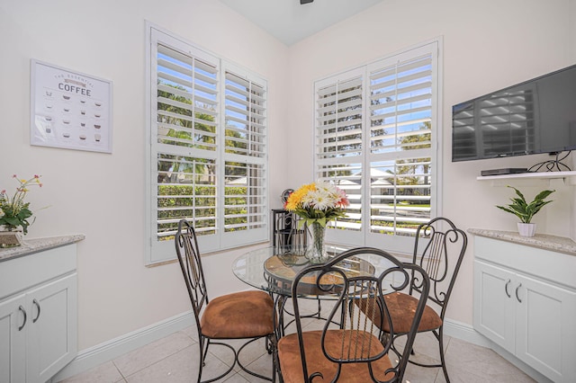 dining space with baseboards, light tile patterned flooring, and a healthy amount of sunlight